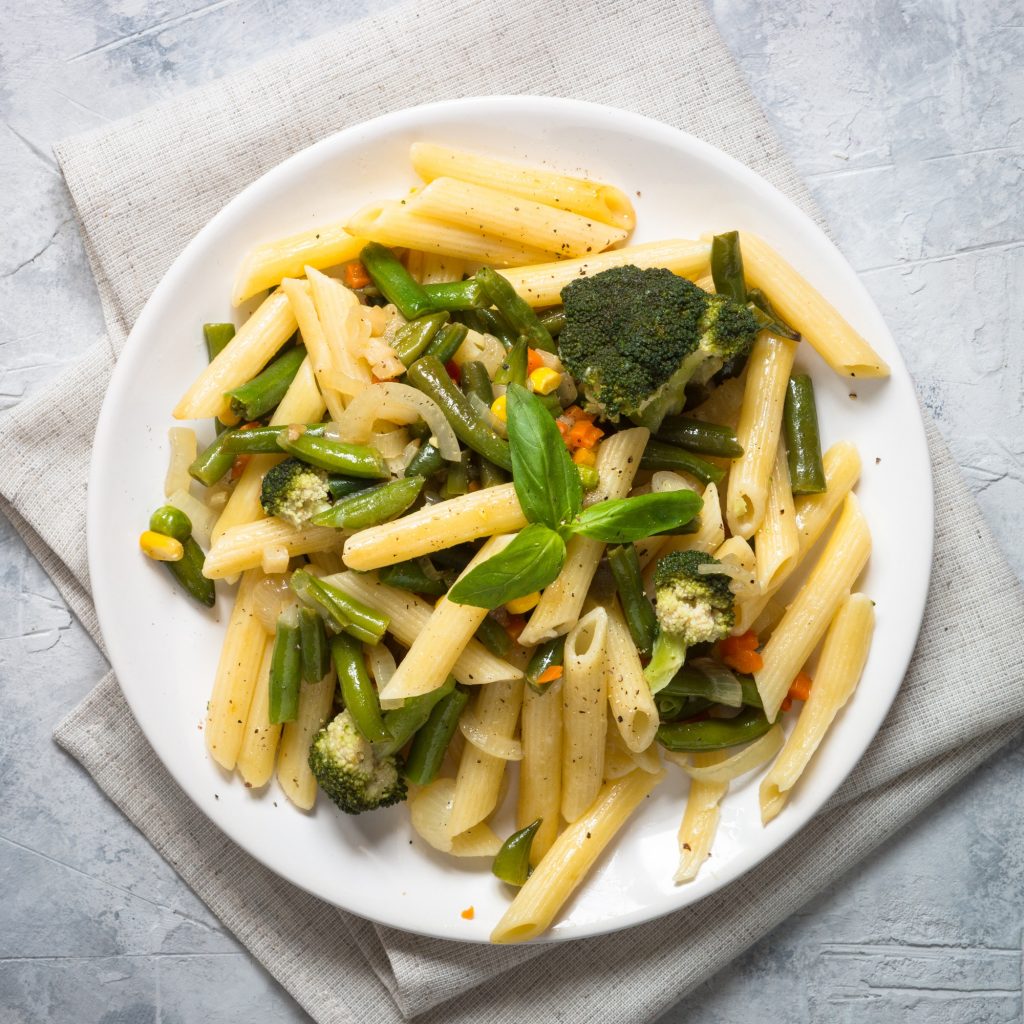 Italian vegetarian pasta penne with green vegetables.